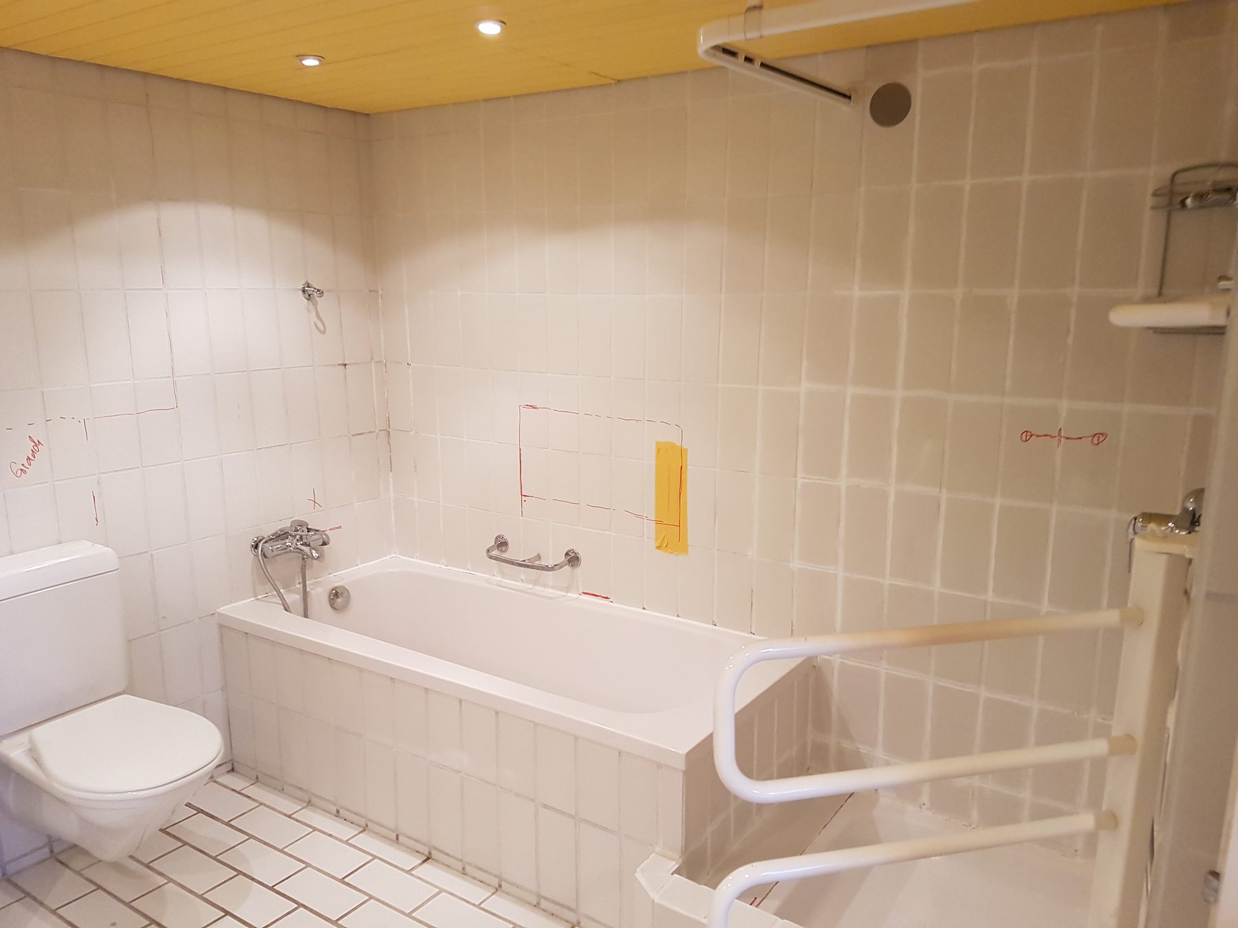 Badezimmer vor dem Umbau mit alten Fliesen und Badewanne